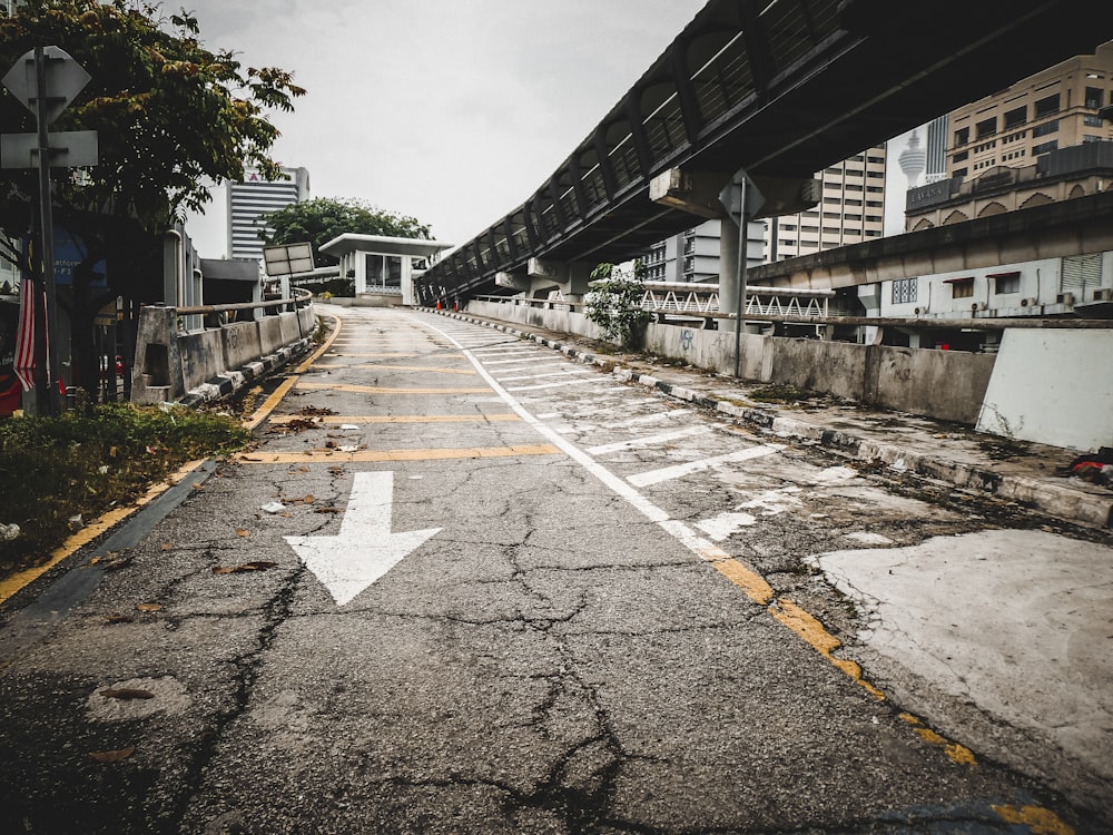 an empty street with a white arrow painted on it