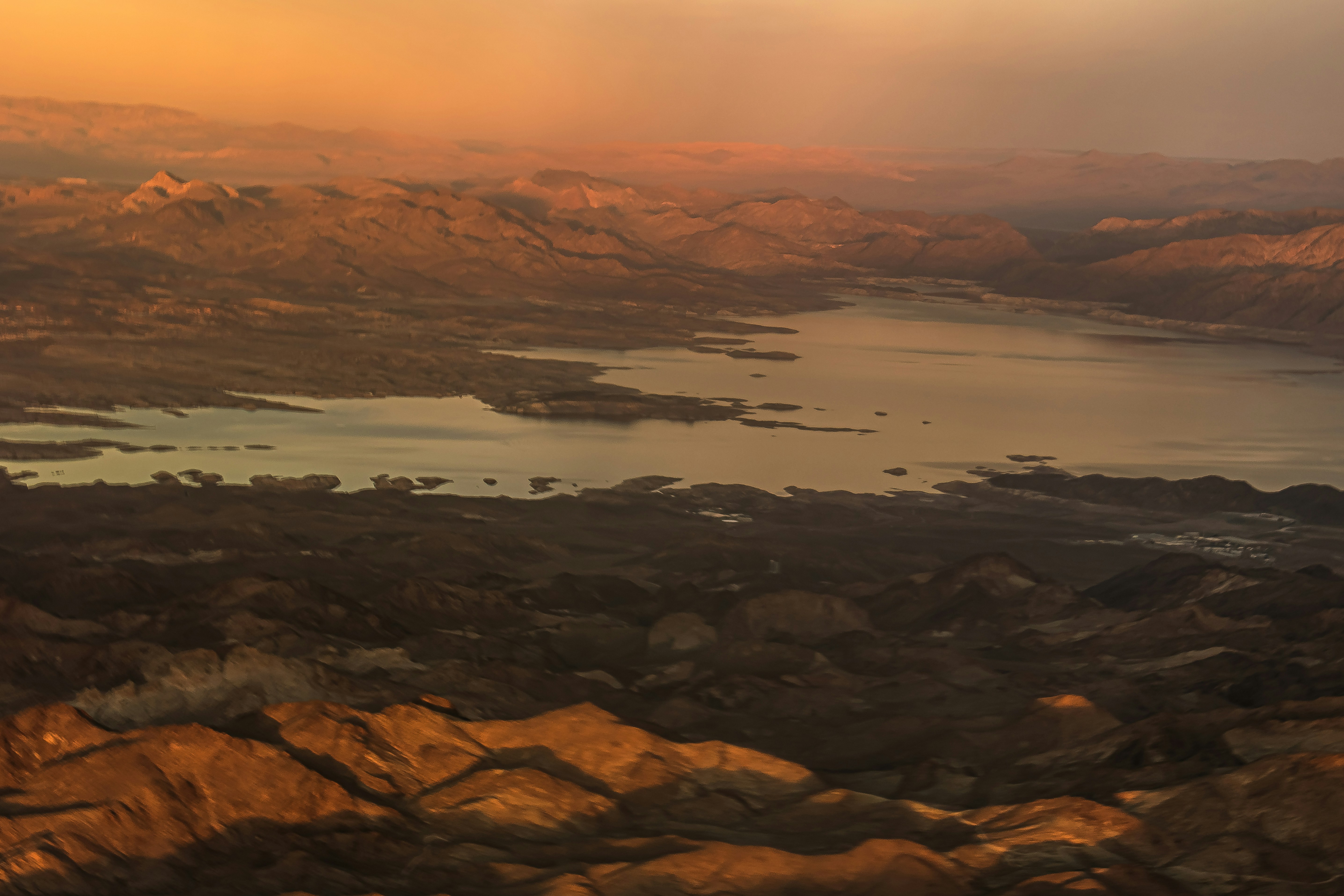 an aerial view of a lake surrounded by mountains