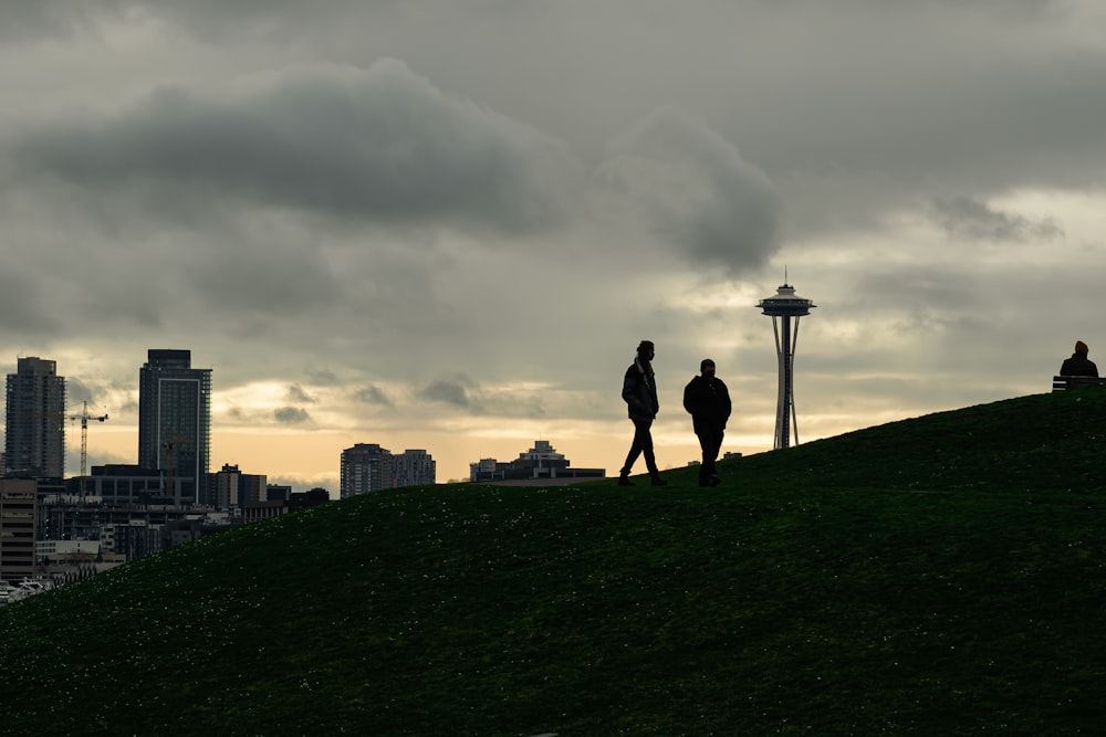 a couple of people that are standing on a hill