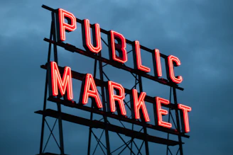 a public market sign lit up at night