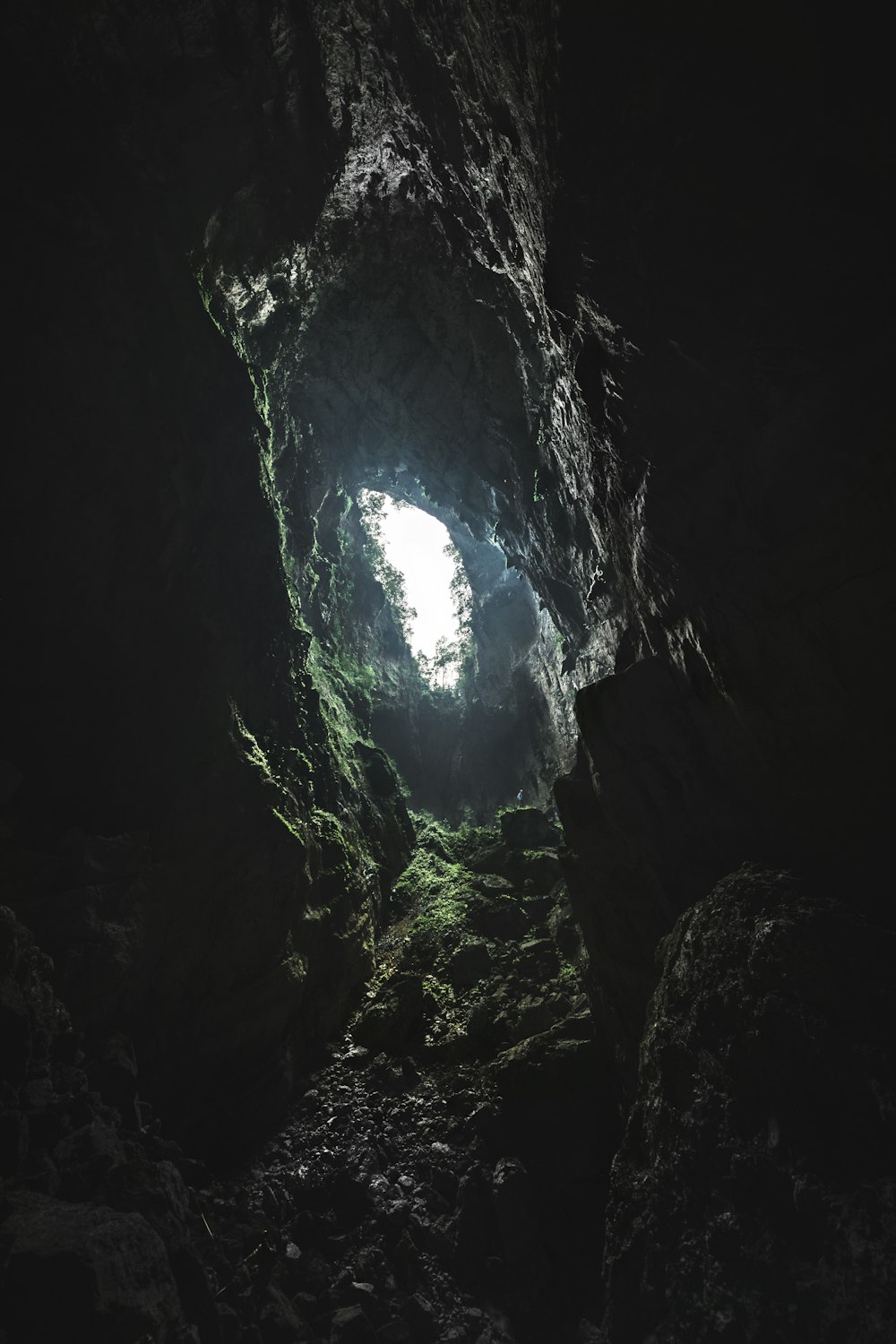 uma caverna escura com uma luz no final