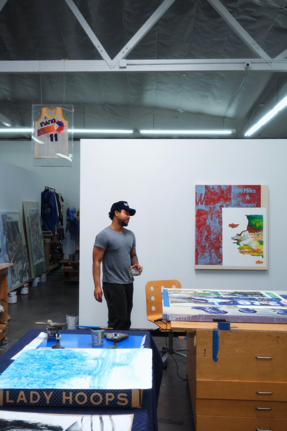 a man standing in a room with a lot of art on the walls