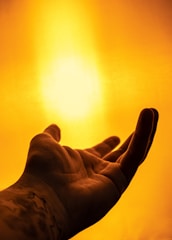 A hand is reaching out towards a bright, golden light. The background is filled with a warm, glowing ambiance, creating a sense of warmth and serenity.