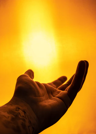 A warm, serene illustration of hands reaching out to connect under a soft glowing light.