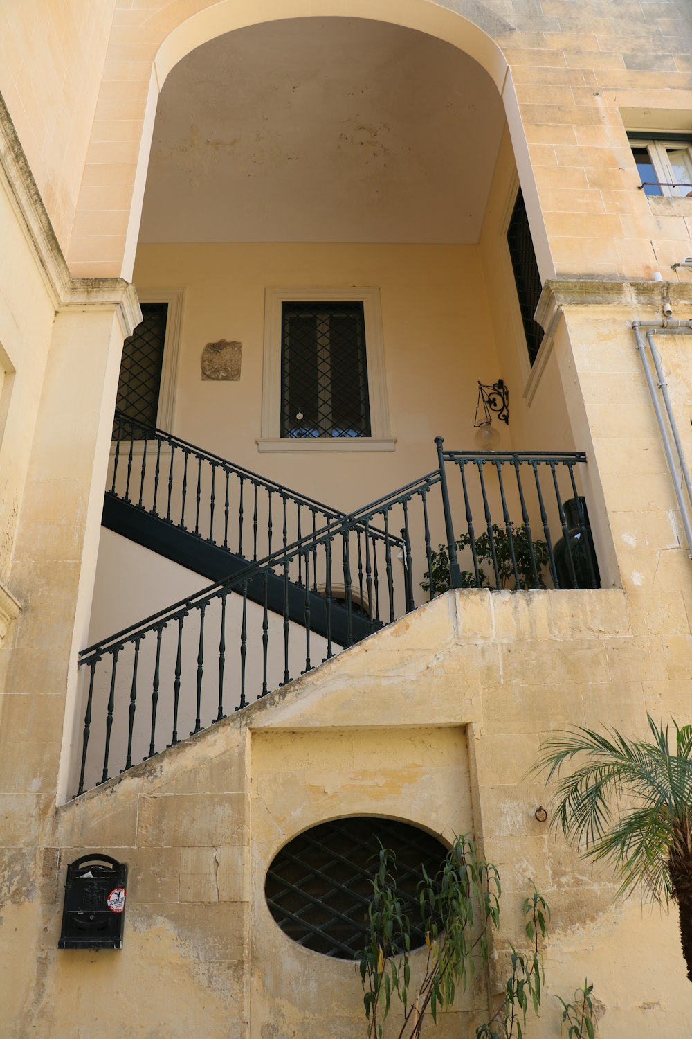 a staircase leading up to a building with a potted plant