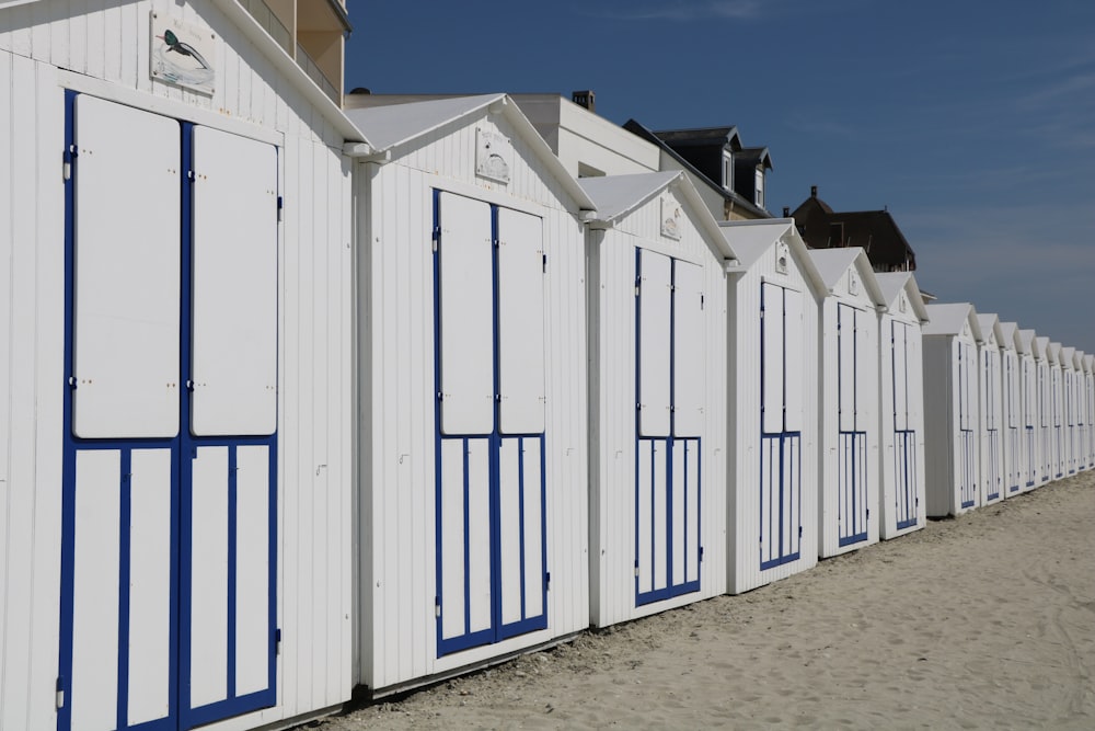 a row of white beach huts sitting next to each other