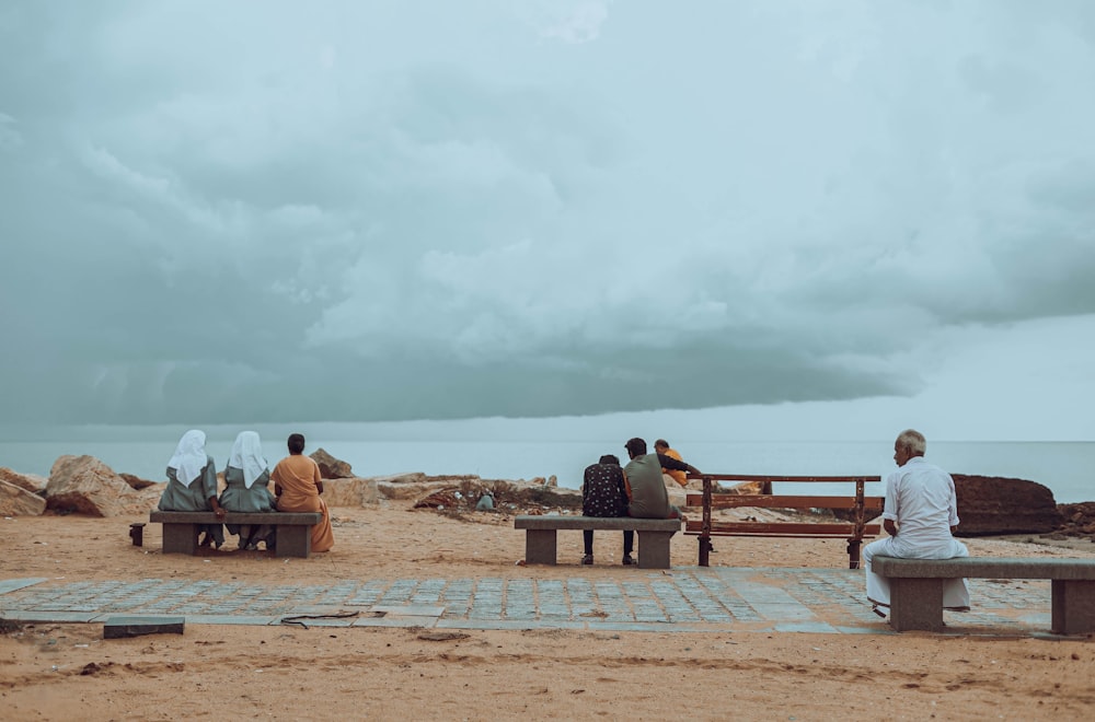 a group of people sitting on top of a wooden bench