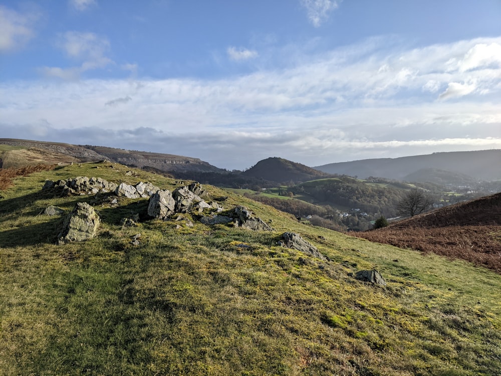 a grassy hill with rocks and grass on it