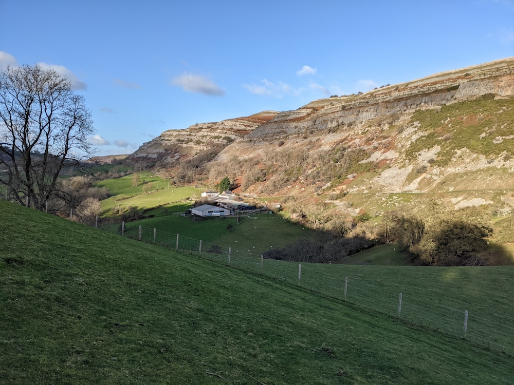 a grassy hill with a house on top of it