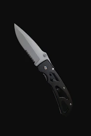 A tactical folding knife with a rugged grip and partially serrated blade displayed on tactical gear.
