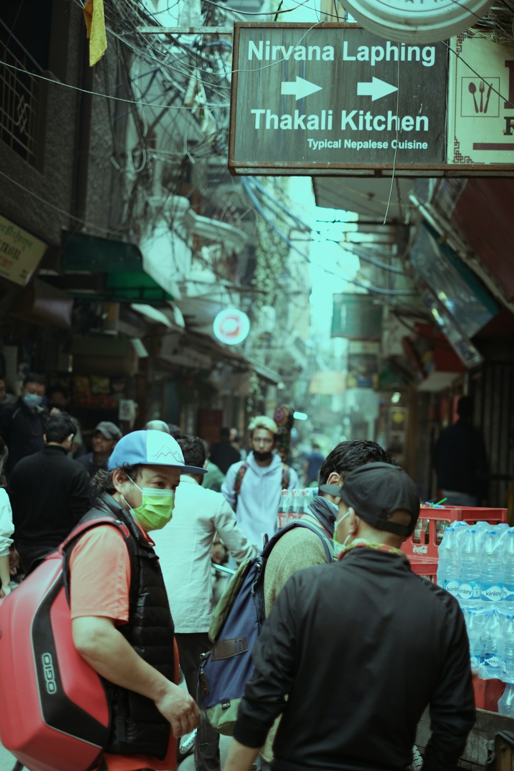 a group of people walking down a street next to a clock