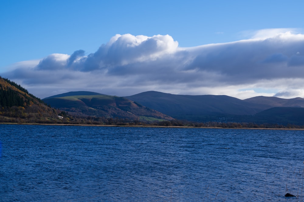 a body of water with mountains in the background