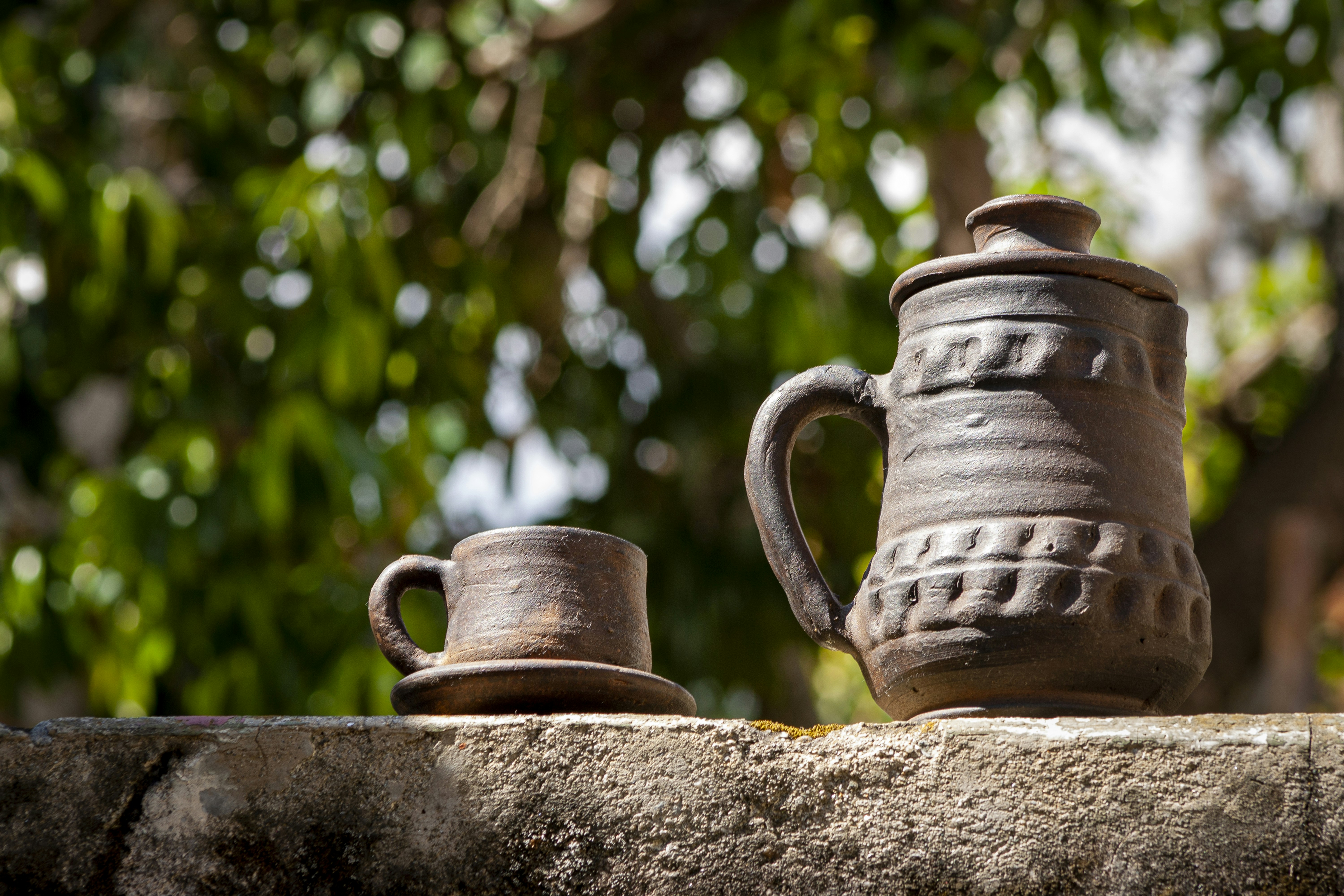 a couple of cups sitting on top of a stone wall