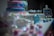 A decorative table is set with a variety of colorful treats, including a tiered cake with pink and blue layers. There are cake pops with designs, pastel cupcakes, and a small chalkboard sign that reads 'Boy or Girl?'. Sparkling decorations adorn the table, suggesting a festive atmosphere.
