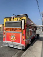 A vibrant red food truck serving fresh street tacos with colorful signage.