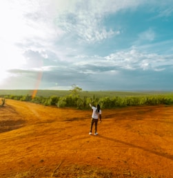 a person standing in the middle of a dirt road