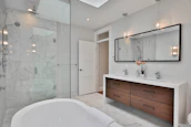 a bathroom with a large white bathtub next to a walk in shower