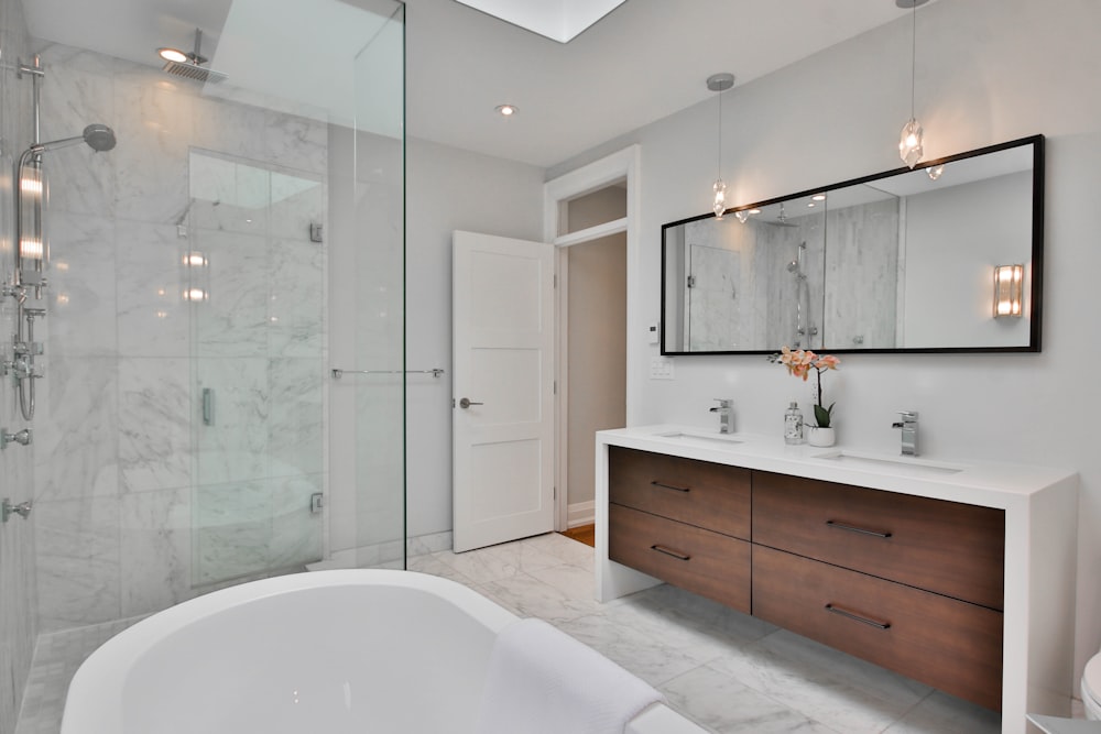 ein Badezimmer mit einer großen weißen Badewanne neben einer begehbaren Dusche