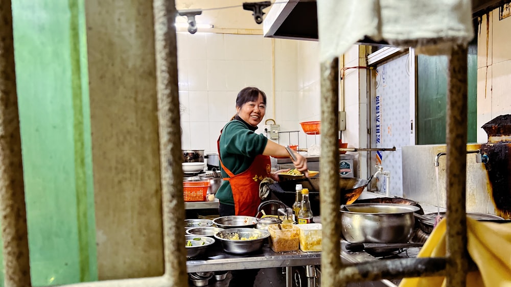 a woman standing in a kitchen preparing food