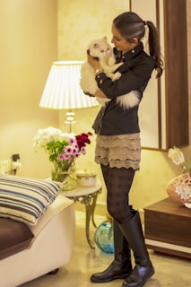 Smiling woman holding a package from an online pet store in a cozy living room.