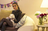 A stylish cat dressed in a vibrant custom shirt sitting on a cozy couch.