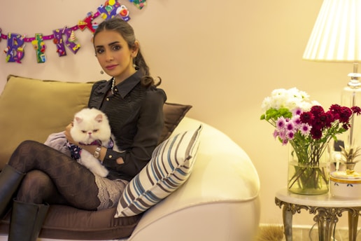 A cozy living room scene with a happy person browsing cat profiles on a tablet.