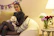 A joyful customer holding a colorful cat-themed tote bag from colaamiga, smiling warmly in a cozy home setting.