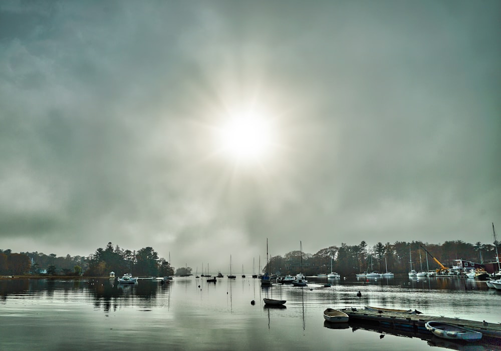 the sun is shining over the water and boats are in the water