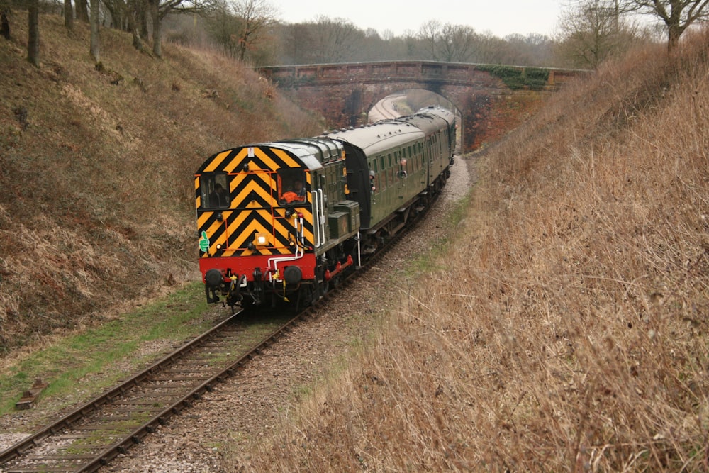 a train traveling down train tracks next to a field