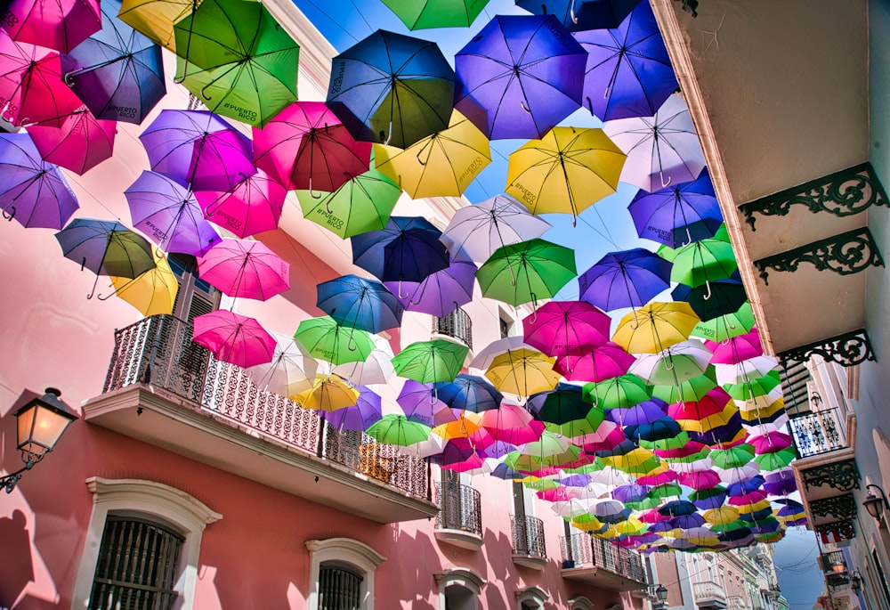 a bunch of colorful umbrellas hanging from a building