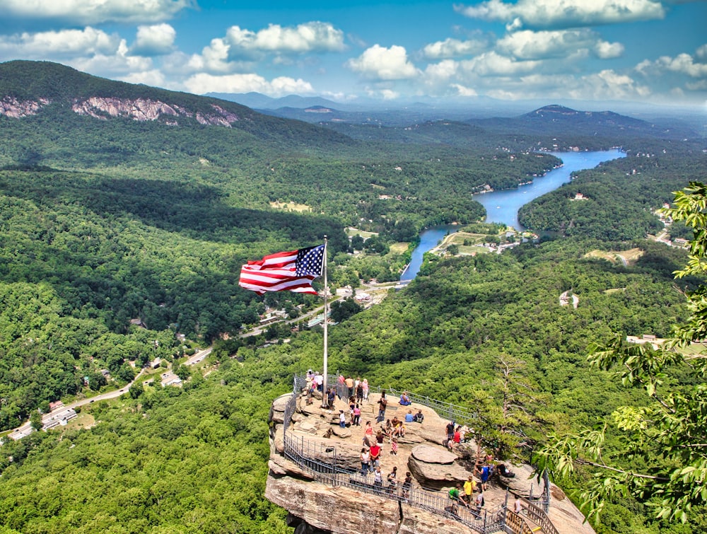 a flag flying on top of a mountain next to a river