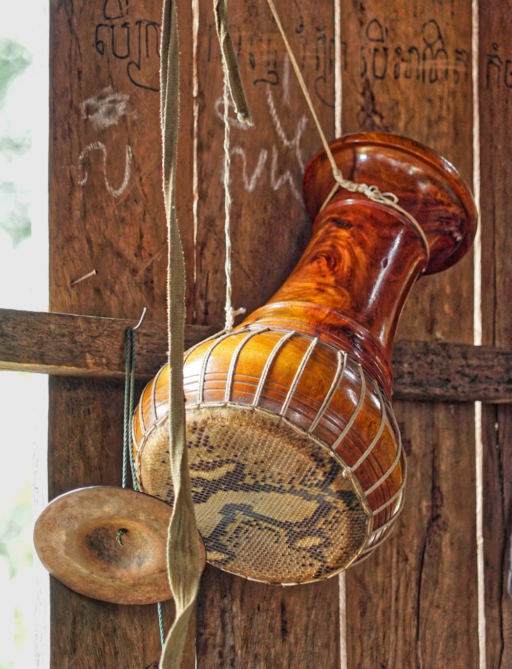 a close up of a wooden object hanging from a rope