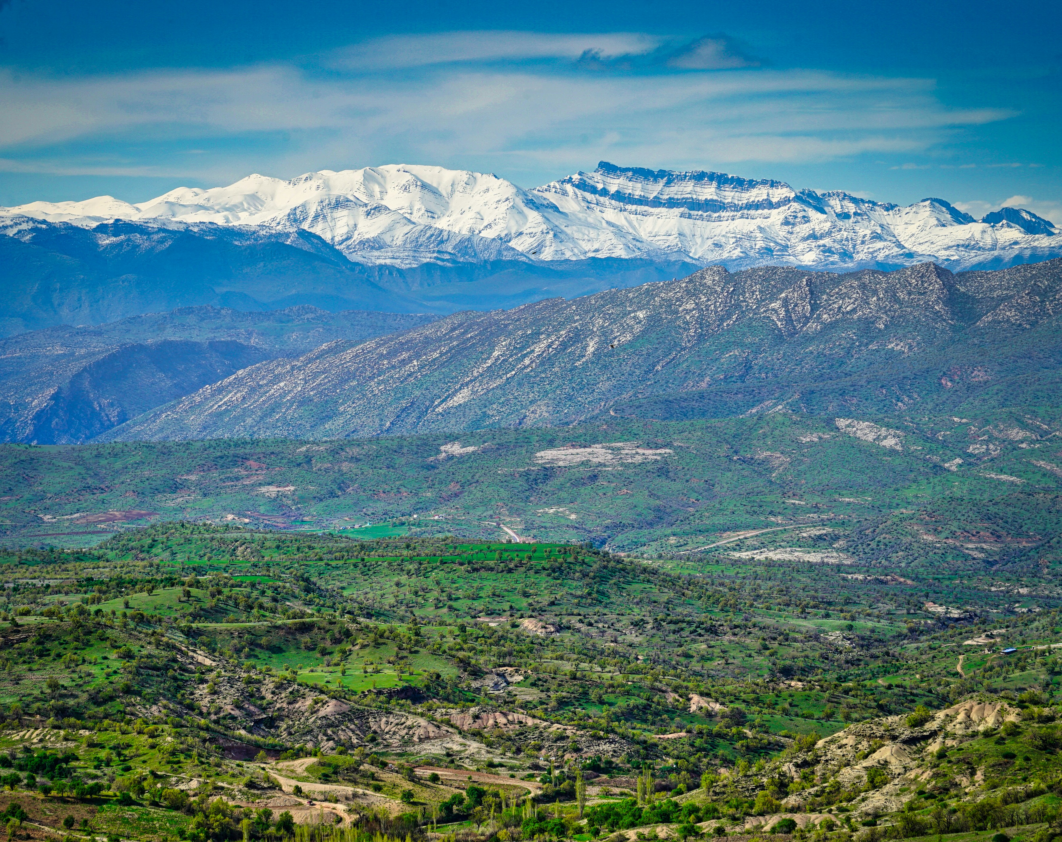 a view of a mountain range with snow capped mountains in the distance