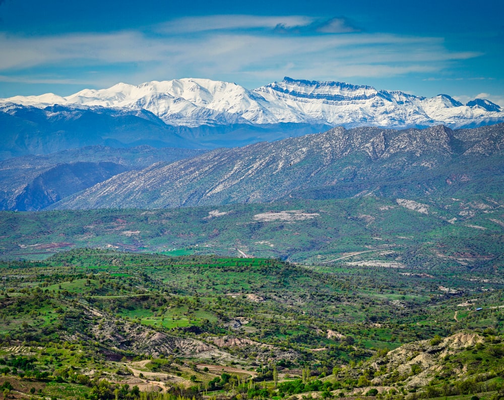 a view of a mountain range with snow capped mountains in the distance