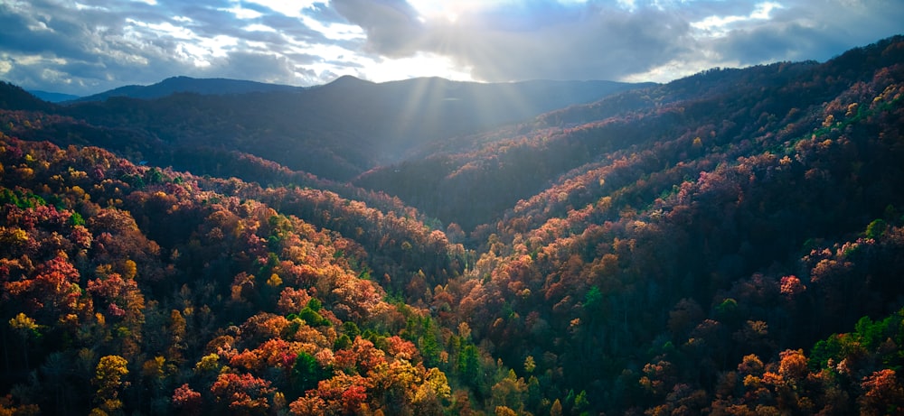 the sun shines through the clouds over the mountains