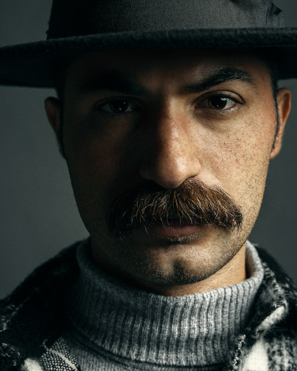 Un homme avec une moustache et un chapeau