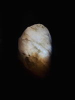 Close-up of a polished natural stone pendant glowing softly in warm light