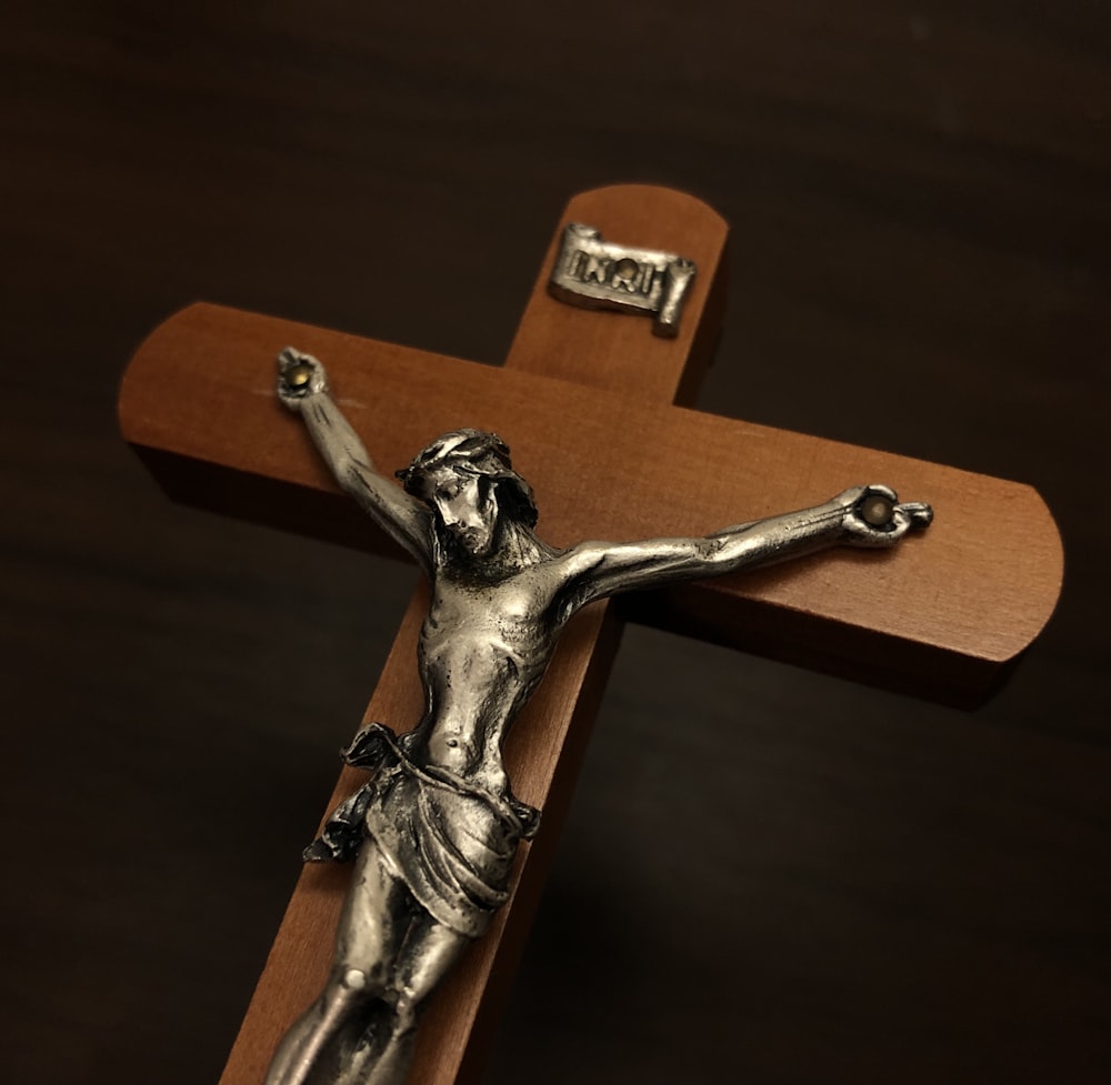 a silver crucifix on a wooden cross