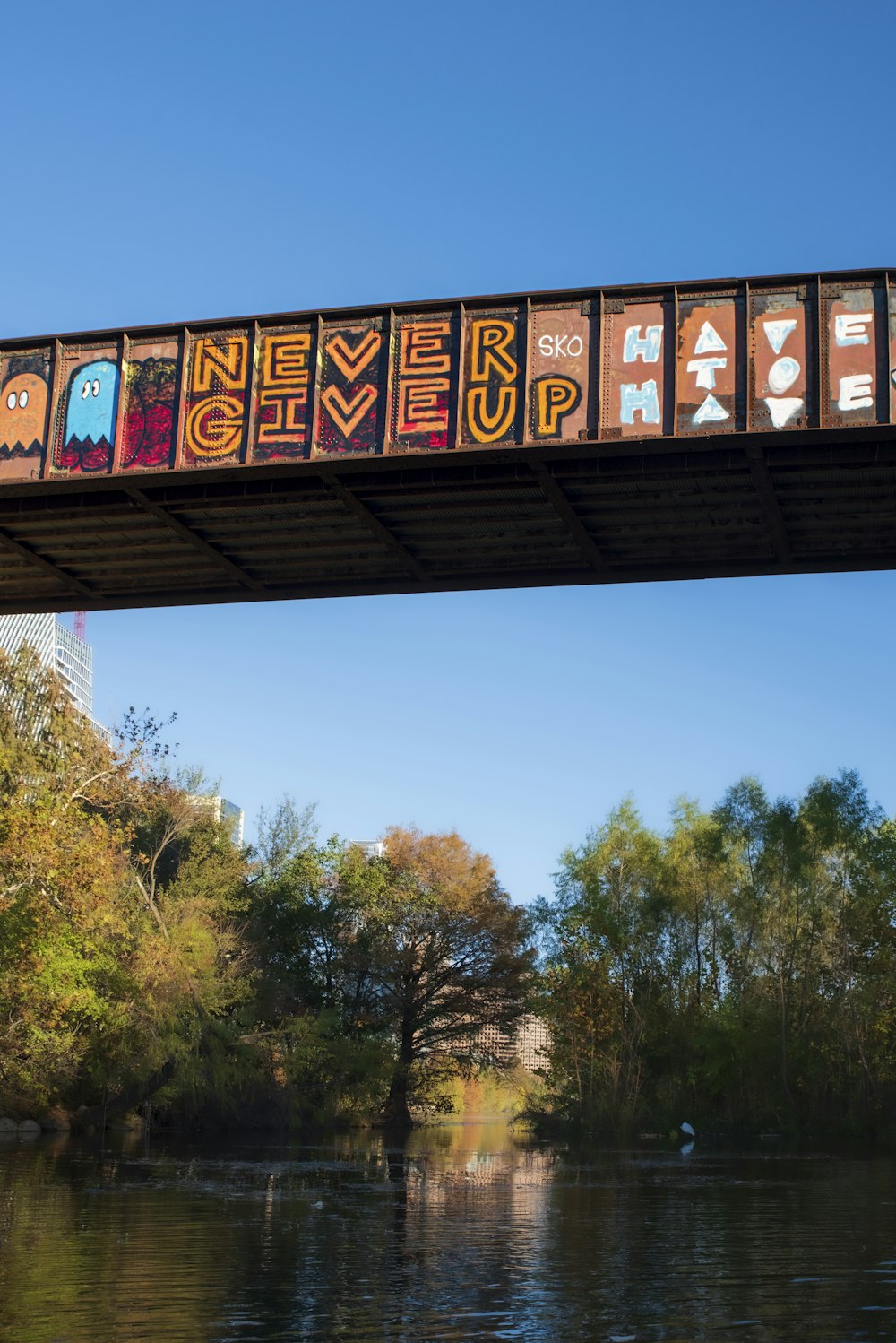 a bridge over a river with a sign that says never give up