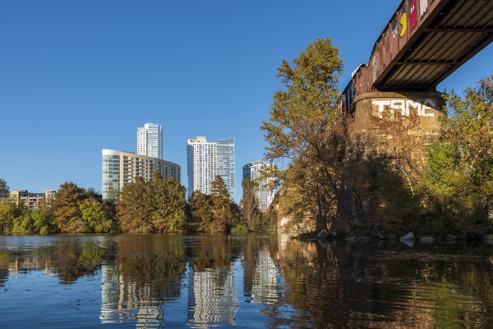 a bridge over a body of water with a city in the background