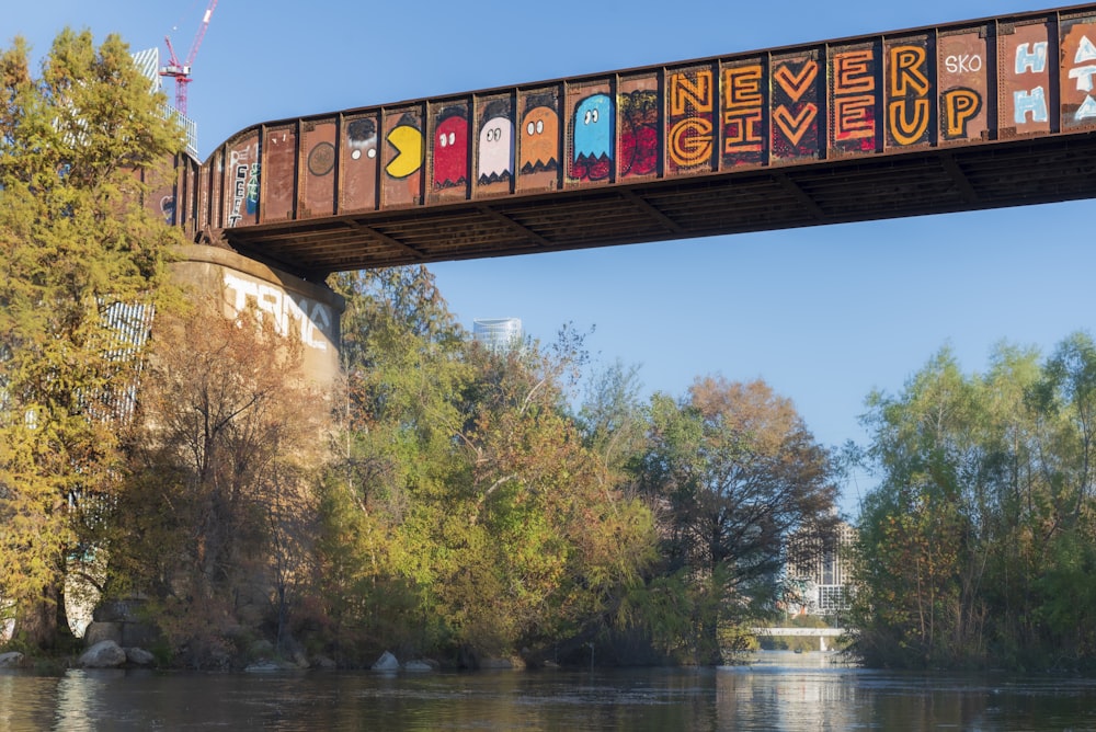 a bridge over a river with graffiti on it