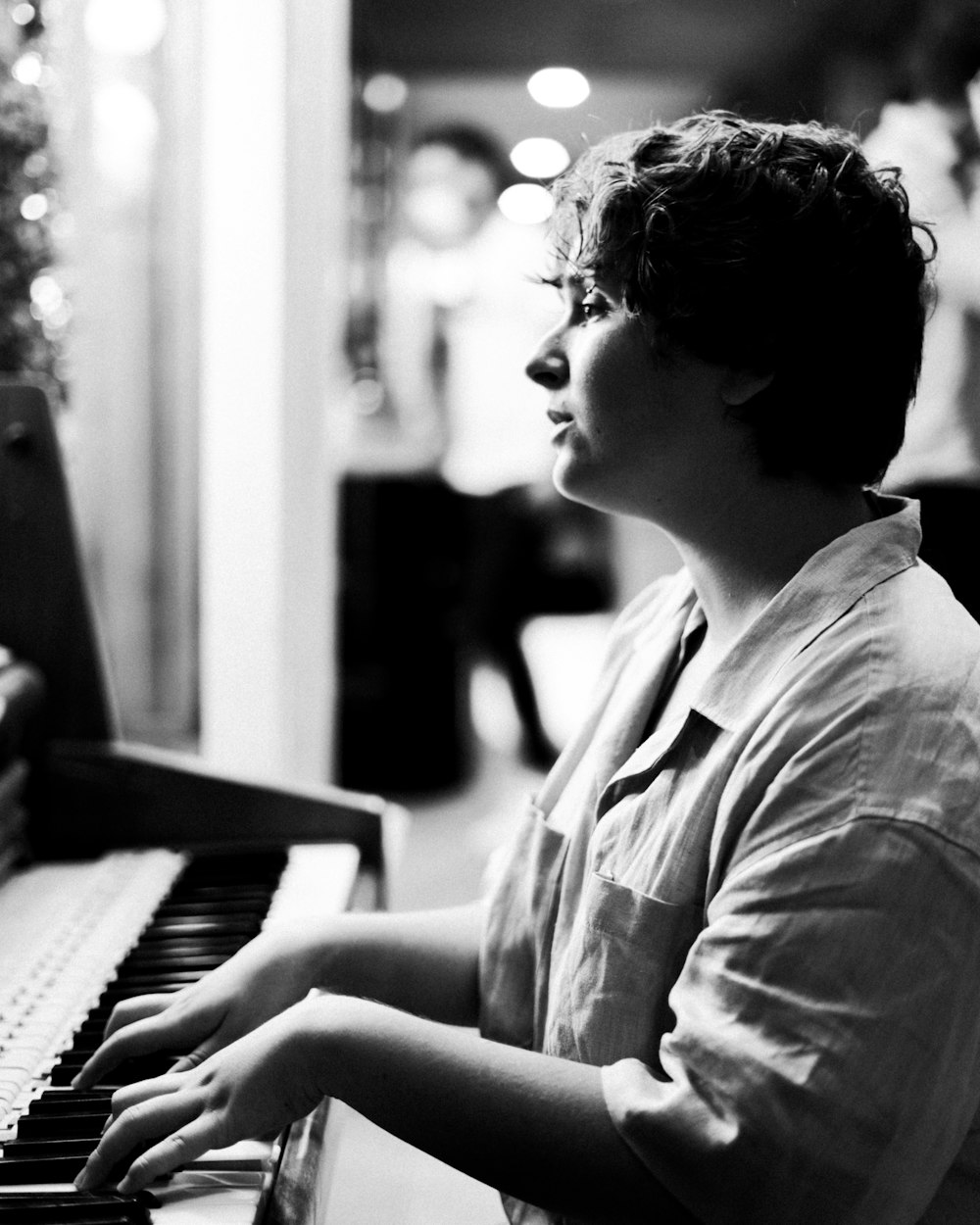 a woman sitting at a piano playing a musical instrument