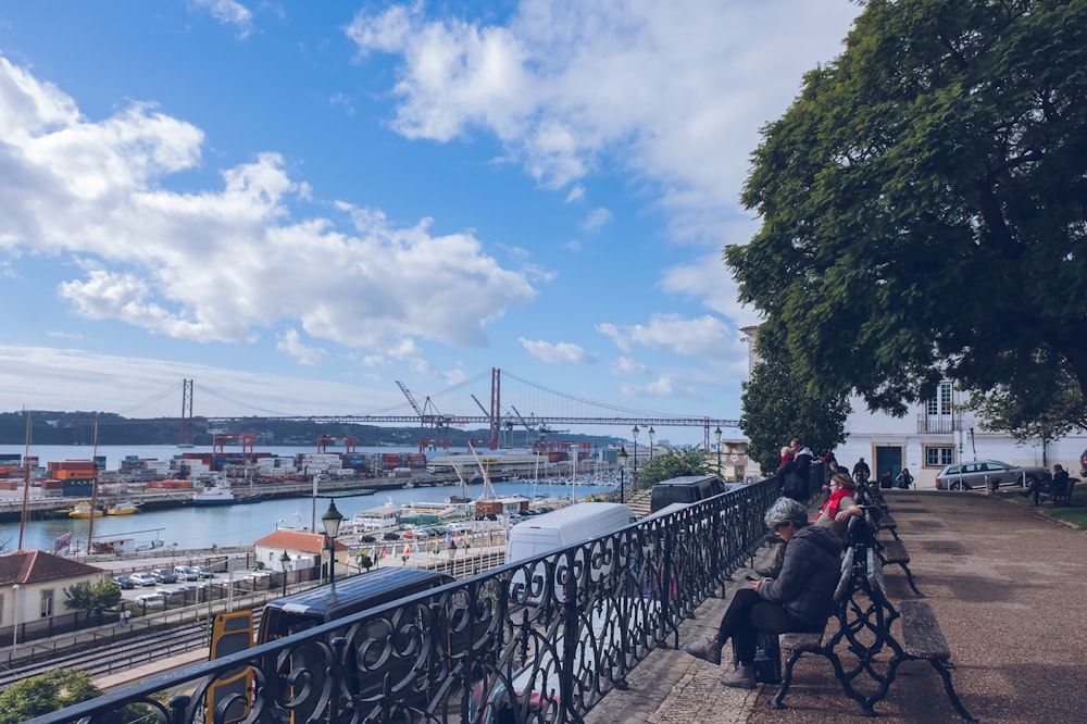 a group of people sitting on benches next to a river