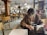 A person using a mobile app on a sleek Apple device in a cozy café setting.