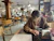 A cheerful man reading customer reviews on his phone in a cozy cafe.