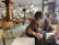 A happy customer browsing a website on a tablet in a cozy cafe.