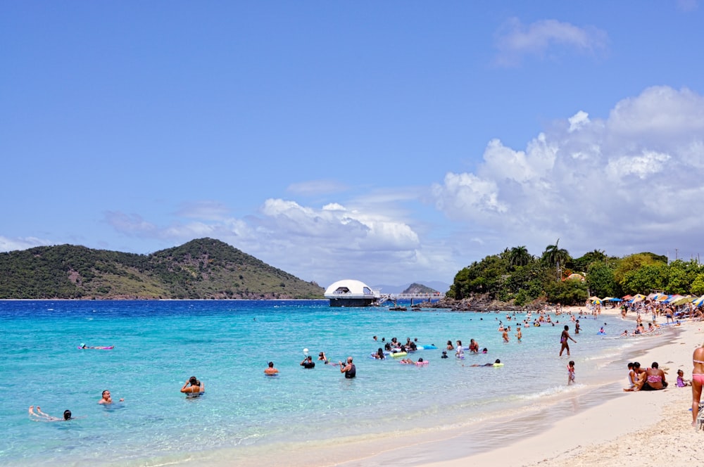 a group of people on a beach near a body of water