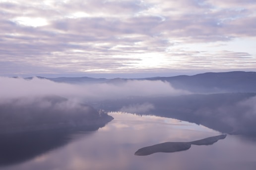 a large body of water surrounded by clouds