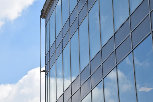 Contemporary glass facade on a commercial building reflecting the blue sky.