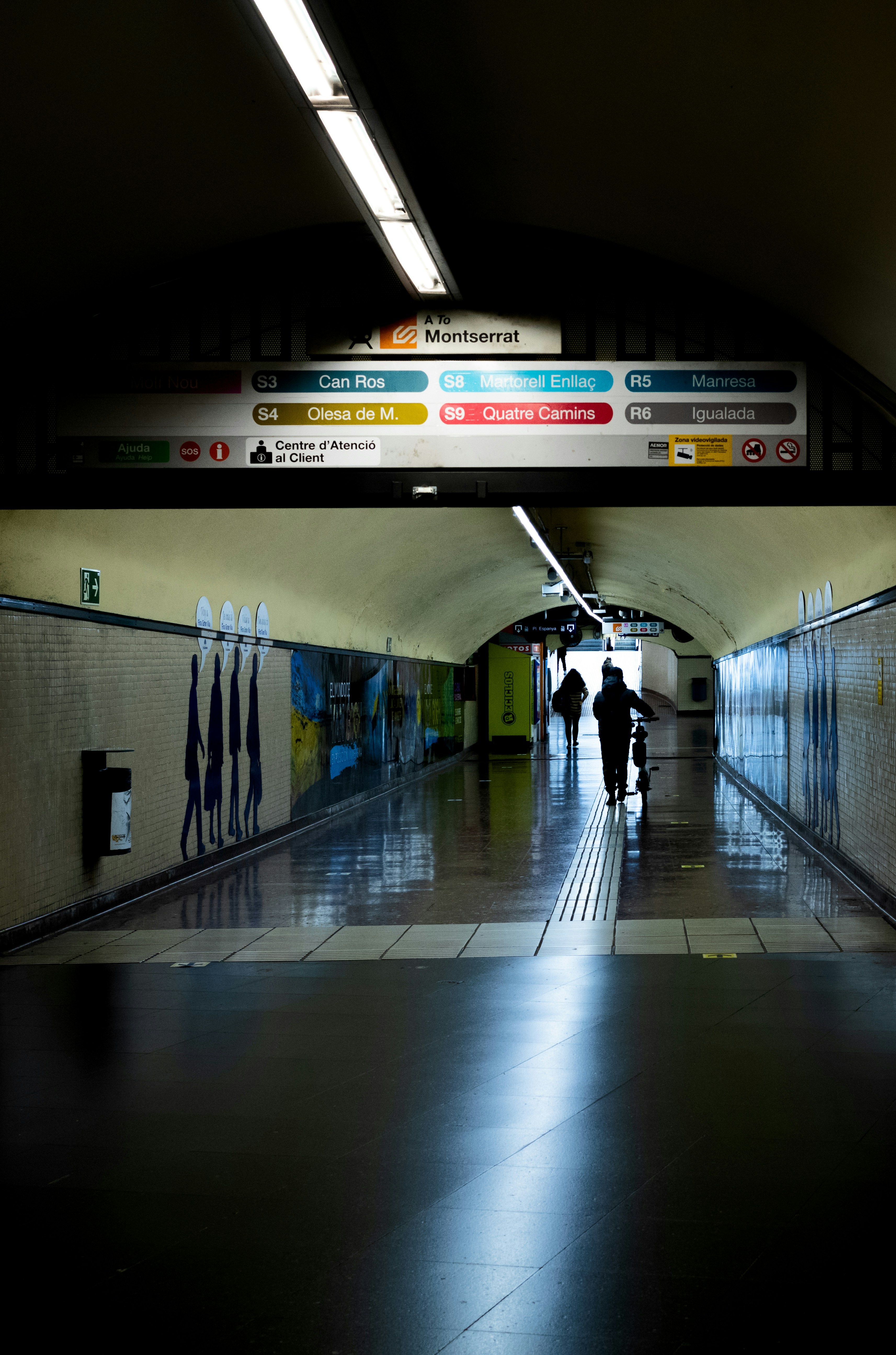 a couple of people walking down a long hallway